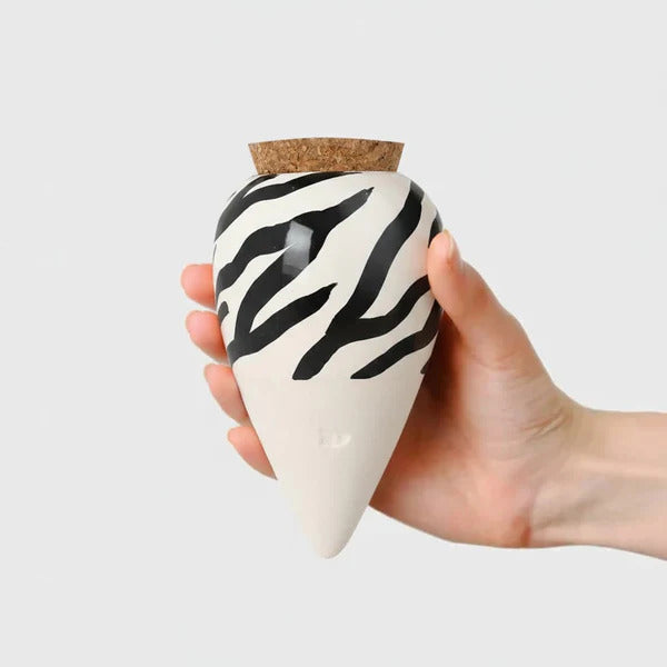 En hånd, der holder en smuk Olla/ferievander med zebrastriber