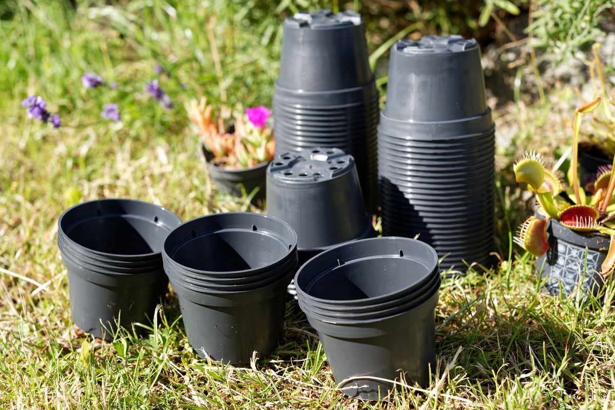 Gruppe af plastik potter på en græsplæne
